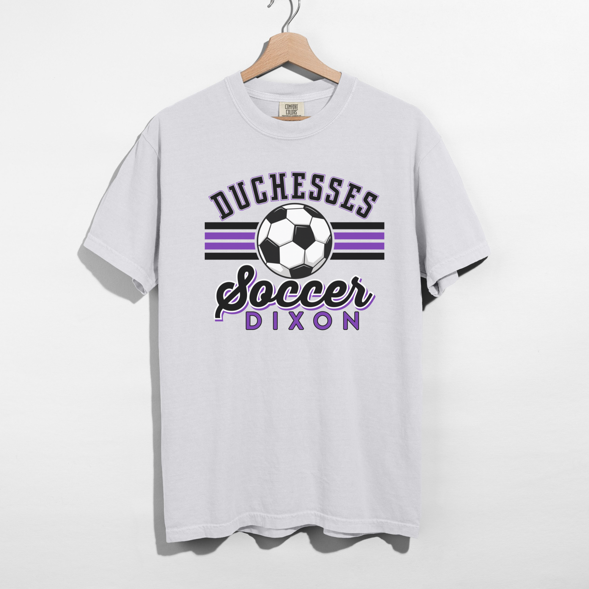 Duchesses Soccer Dixon graphic printed on white Comfort Colors t-shirt hanging on hanger
