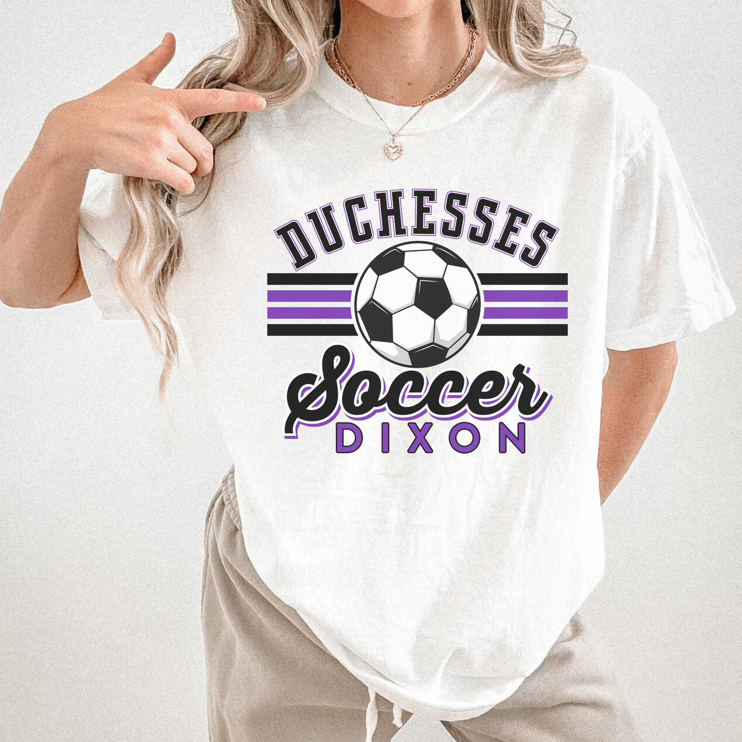 Woman pointing at Duchesses Soccer Dixon purple and black graphic tee on white shirt