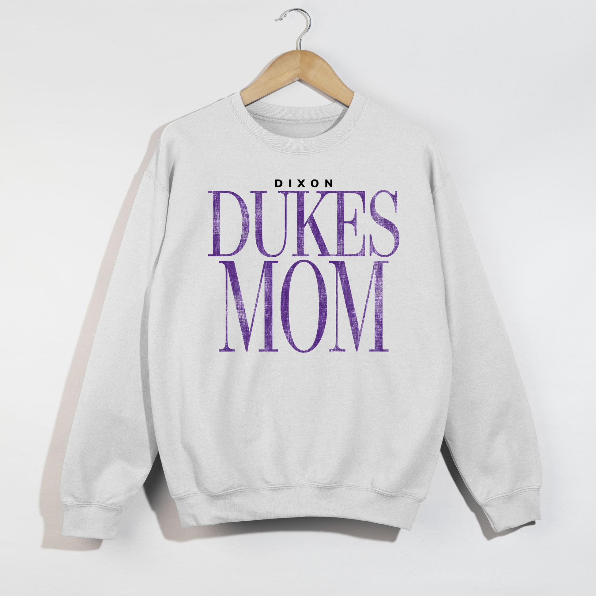 White Dixon Dukes Mom sweatshirt flat lay product image on hanger minimal background