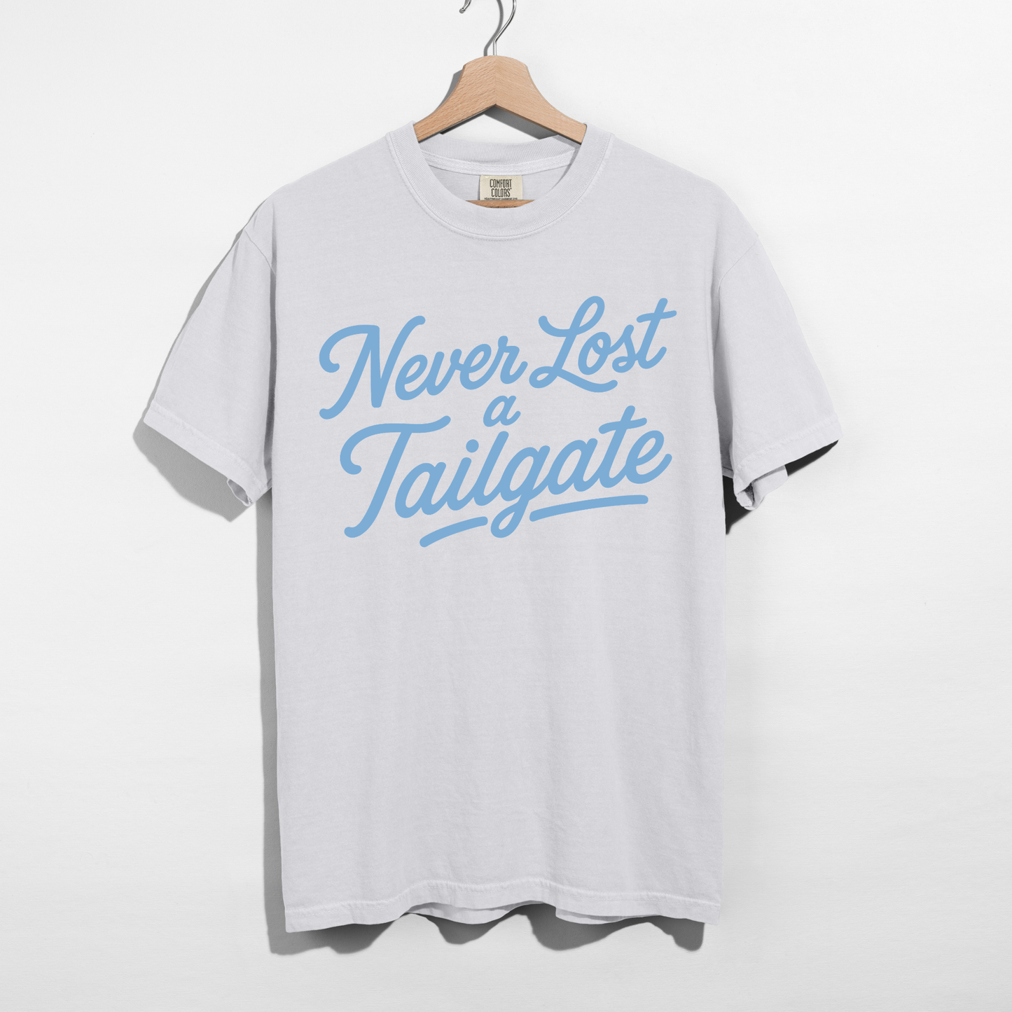 Never Lost a Tailgate white graphic tee with Carolina blue retro lettering for football game day